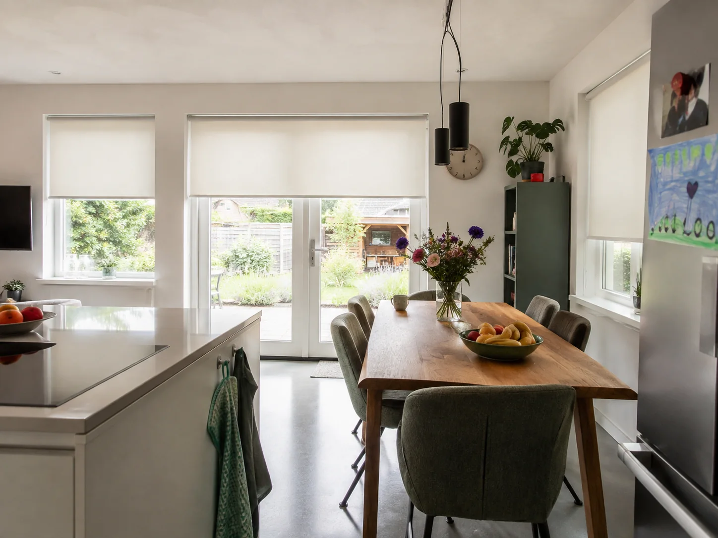 Witte lichtdoorlatende elektrische rolgordijnen in een keuken en leefruimte